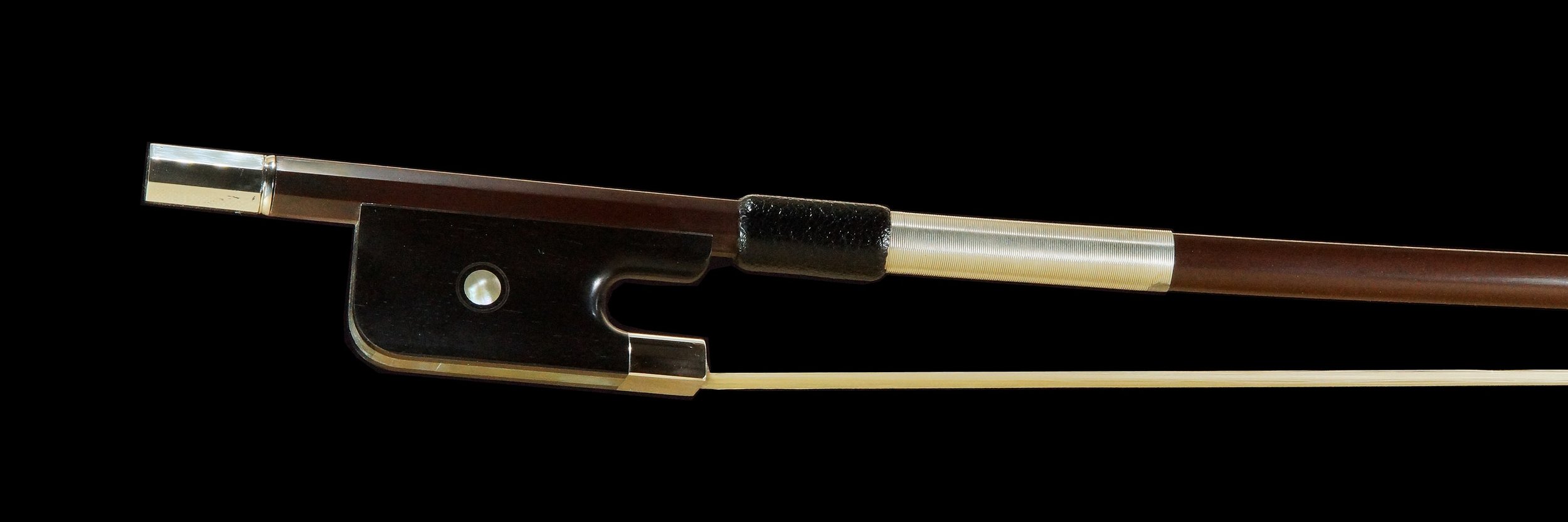 L'image montre un archet de contrebasse français 29 mm, mettant en valeur sa grenouille sombre et ses détails métalliques élégants. Cet archet est conçu pour offrir une maniabilité exceptionnelle et une précision optimale, permettant aux musiciens de contrebasse d'explorer toute la gamme de leur instrument avec aisance.