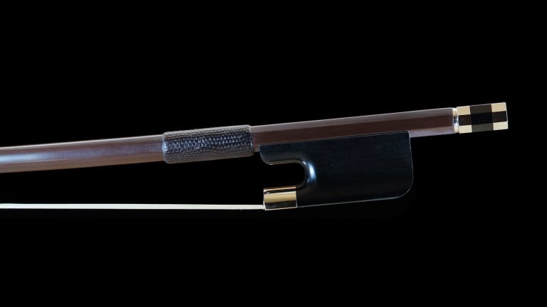 L'image montre un archet français de contrebasse 30mm, avec une baguette en bois et des finitions en métal. La grenouille noire est élégamment conçue pour offrir une excellente prise en main et une maniabilité optimale. Cet archet est idéal pour les contrebassistes recherchant précision et expressivité dans leur jeu.