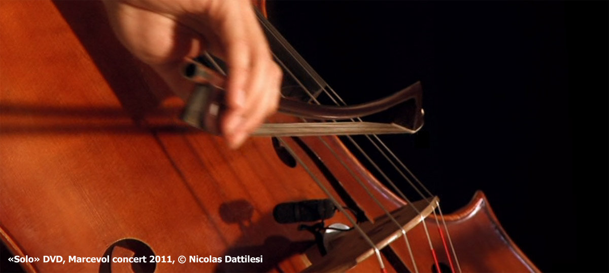 L'image montre une main tenant un archet de contrebasse français modèle Renaud Garcia pendant un concert. L'archet est utilisé pour jouer avec précision et expressivité, démontrant l'importance de cet outil pour obtenir un son riche et puissant.