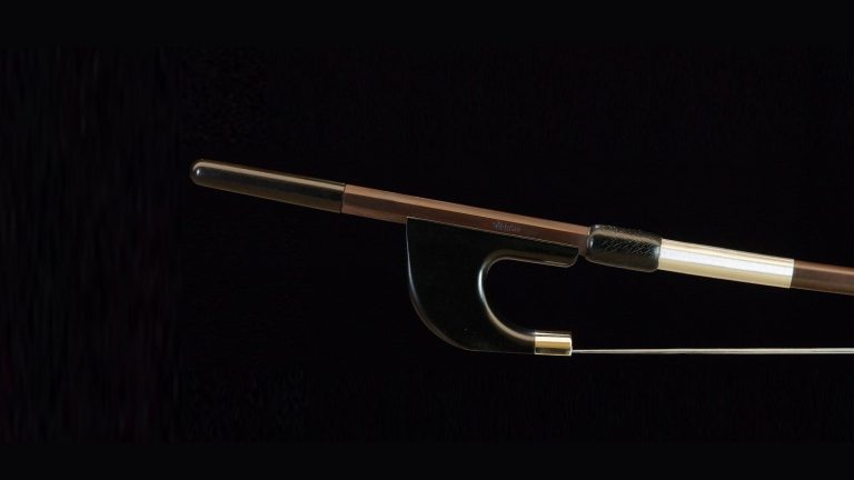 L'image montre un archet de contrebasse allemand avec une grenouille en composite, combinant des matériaux traditionnels et modernes pour offrir une meilleure performance et durabilité. Cet archet est conçu pour fournir une excellente maniabilité et une réponse précise, idéal pour les contrebassistes recherchant un instrument de haute qualité avec des innovations technologiques.