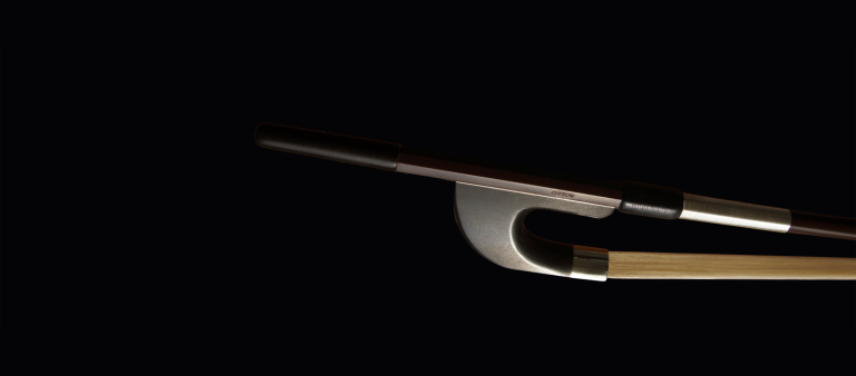 Cette image montre de près la hausse d'un archet de contrebasse allemand avec une hausse en ébène. La finition lisse de l'ébène et les détails métalliques ajoutent une touche d'élégance et de sophistication à l'archet, offrant une prise confortable et sécurisée.
