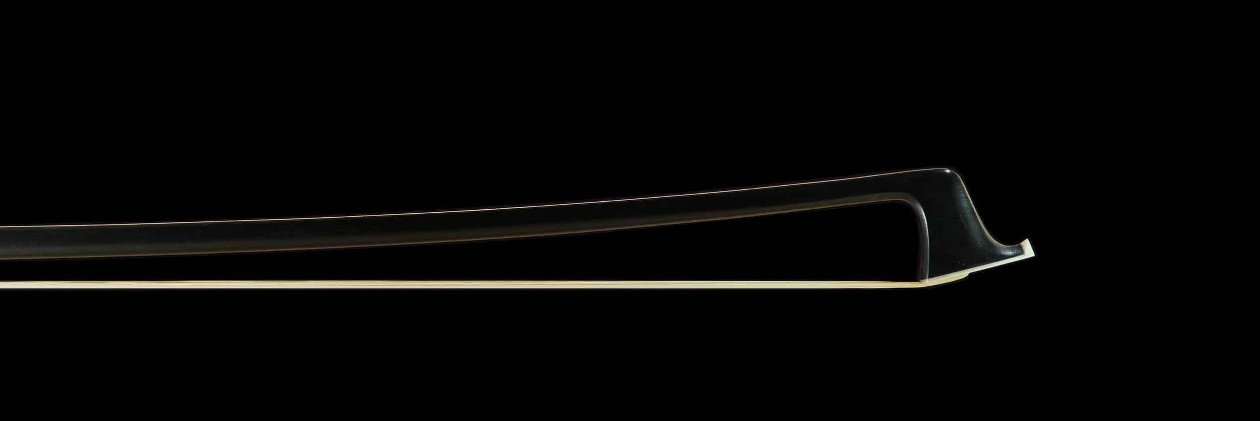 une vue détaillée de la tête d'un archet, également de couleur noire, mettant en valeur sa forme soignée et équilibrée, idéale pour les musiciens cherchant à améliorer leur jeu avec un instrument de haute qualité.