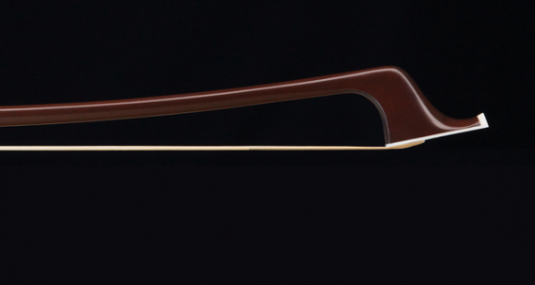 Cette image montre un gros plan d'un archet en carbone contre un fond noir, mettant en valeur la courbure élégante et la finesse de la baguette. La finition lisse et la couleur brun foncé de l'archet contrastent avec le fond sombre, soulignant la sophistication de cet outil de musicien.
